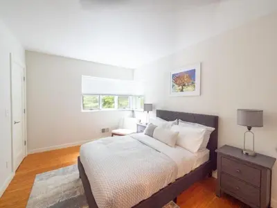 a bedroom with a bed and a table and a window at Berkshire Vacation Rentals: High End Berkshires Getaway in East Hillsdale