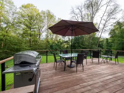 a patio with a grill and a table with an umbrella at Berkshire Vacation Rentals: High End Berkshires Getaway in East Hillsdale