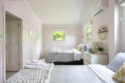 a white bedroom with two beds and a window at Berkshire Vacation Rentals: Great Barrington Walkable To Lake And Town in Great Barrington