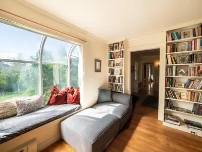 a living room with a couch and a large window at Berkshire Vacation Rentals: Renovated Five Bedrooms In Historic Williamstown in Williamstown