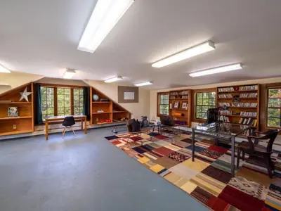 a large room with a library with a large rug at Berkshire Vacation Rentals: Renovated Five Bedrooms In Historic Williamstown in Williamstown