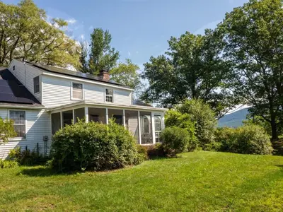an old white house with a green lawn at Berkshire Vacation Rentals: Renovated Five Bedrooms In Historic Williamstown in Williamstown