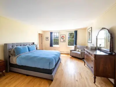 a bedroom with a bed and a dresser and a mirror at Berkshire Vacation Rentals: Renovated Five Bedrooms In Historic Williamstown in Williamstown