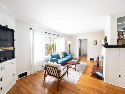 a living room with a blue couch and a table at Berkshire Vacation Rentals: Chic Pittsfield Home With A View in Pittsfield