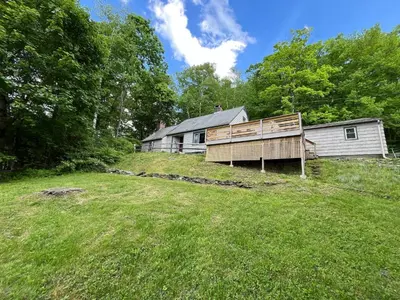 a house on a hill next to a yard at Berkshire Vacation Rentals: Chic Pittsfield Home With A View in Pittsfield