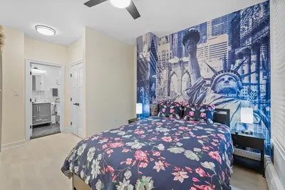 a bedroom with a bed with a mural on the wall at 10Min to NYC - 2BR/2.5Bath-3Beds-Free Parking-No Chores in Hoboken
