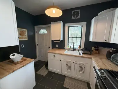 a kitchen with white cabinets and a sink at Schoolhouse No. 11 * Hudson Valley Upstate Getaway in Stone Ridge