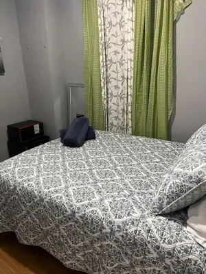 a bedroom with a bed with a blue and white comforter at Room in a 2 Bedrooms apt. 10 minutes to Time Square! in West New York