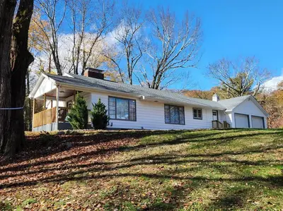 a white house on top of a grassy hill at Near Marist/Vassar/Culinary Inst./Historic Sites! in Pleasant Valley