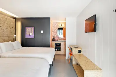 a hotel room with two beds and a table at The Brooks Motel in Hillsdale