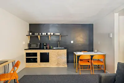 a kitchen with orange chairs and a table and a counter at The Brooks Motel in Hillsdale