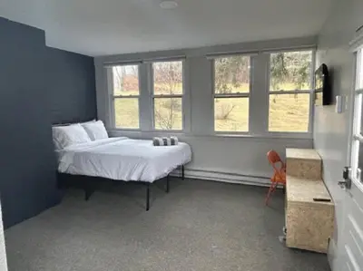 a bedroom with a bed and two windows at The Brooks Motel in Hillsdale