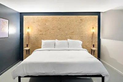 a bedroom with a large white bed with two side tables at The Brooks Motel in Hillsdale