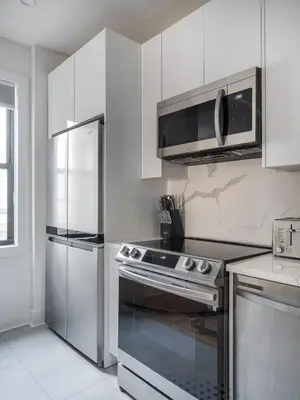 a kitchen with a stainless steel stove and a microwave at Modern Three Bedroom Brooklyn Condo-Hotel in Brooklyn