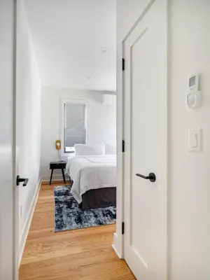 a white bedroom with a bed and a mirror at Modern Three Bedroom Brooklyn Condo-Hotel in Brooklyn
