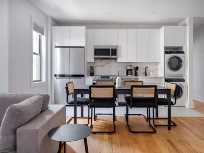 a kitchen with a table and chairs in a living room at Modern Three Bedroom Brooklyn Condo-Hotel in Brooklyn