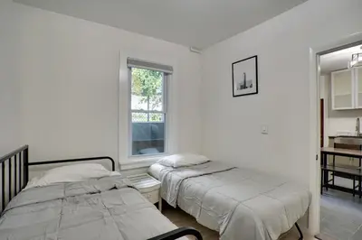 two beds in a white room with a window at Modern Hastings-On-Hudson Home Near River! in Hastings-on-Hudson