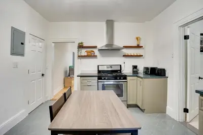 a kitchen with a wooden table and a stove at Modern Hastings-On-Hudson Home Near River! in Hastings-on-Hudson