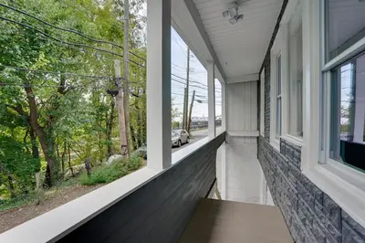 an empty porch with windows looking out at a car at Modern Hastings-On-Hudson Home Near River! in Hastings-on-Hudson