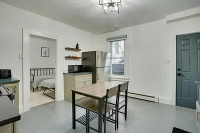a kitchen with a table and a refrigerator at Modern Hastings-On-Hudson Home Near River! in Hastings-on-Hudson