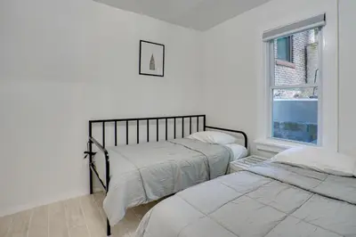 two beds in a white room with a window at Modern Hastings-On-Hudson Home Near River! in Hastings-on-Hudson