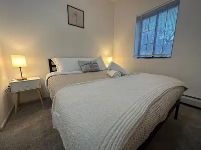 a bedroom with a bed and a lamp and a window at GREAT VALUE Luxe Style Queen Beds WD Parking in Schenectady