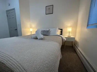 a white bedroom with a bed and two lamps at GREAT VALUE Luxe Style Queen Beds WD Parking in Schenectady