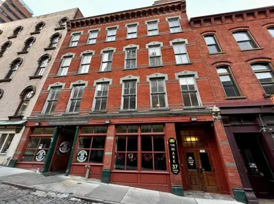 a red brick building with windows on a street at Downtown Albany 1 Bed + Workstation @ Maiden Lane in Albany
