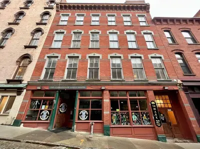 a large brick building with a store in front of it at Downtown Albany 1 Bed + Workstation @ Maiden Lane in Albany