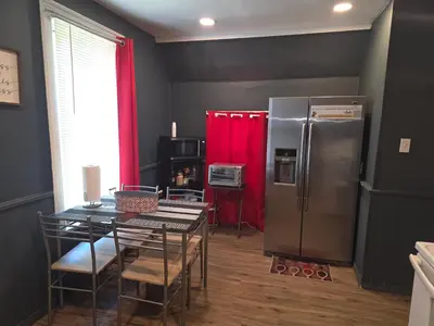 a dining room with a table and a refrigerator at Fashionably cozy2 in Meriden