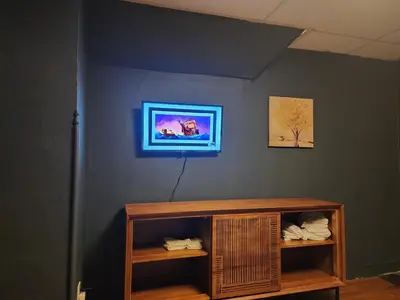 a room with a blue wall with a wooden shelf at Fashionably cozy2 in Meriden