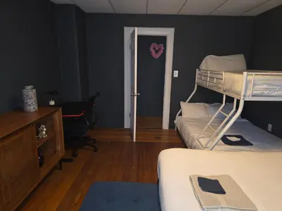 a bedroom with two bunk beds and a desk and a door at Fashionably cozy2 in Meriden
