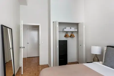 a bedroom with a bed and a mirror and a closet at Fidi 1br w doorman wd nr south st seaport NYC-1306 in New York
