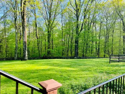 a large green field with a fence and trees at Upmarket Country Retreat, Washington, Connecticut in Washington