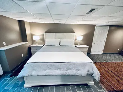 a bedroom with a large bed with two tables and two lamps at Upmarket Country Retreat, Washington, Connecticut in Washington