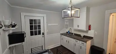 a kitchen with white cabinets and a sink and a chandelier at Private Apt In Middletown-wesleyan in Middletown