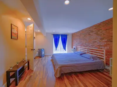 a bedroom with a bed and a brick wall at Stylish 3 bed, minutes to NYC! in Jersey City