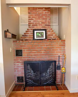 a brick fireplace in a living room at Sunset Cottage #3 in Hamilton
