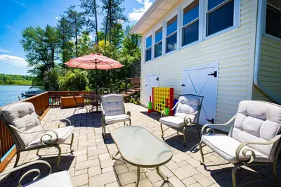 a patio with chairs and an umbrella next to a house at Sunset Cottage #3 in Hamilton