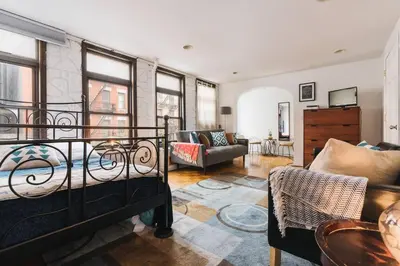 a living room with a bed and a couch at East Village Townhouse in New York