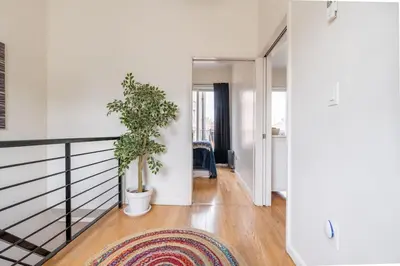 a hallway with a staircase with a rug and a plant at East Village Townhouse in New York