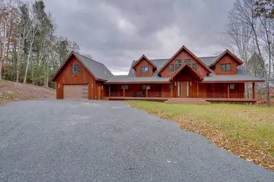 a large wooden house with a driveway in front of it at Brand New Luxury Ski Cabin - 2 Mi to Windham Mtn! in Windham