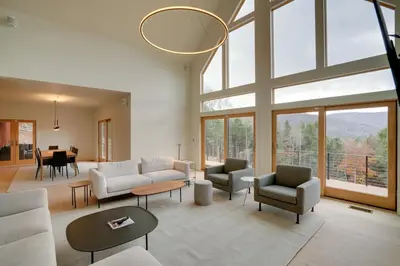 a living room with white furniture and a large window at Brand New Luxury Ski Cabin - 2 Mi to Windham Mtn! in Windham