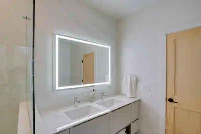 a white bathroom with two sinks and a mirror at Brand New Luxury Ski Cabin - 2 Mi to Windham Mtn! in Windham