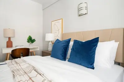 a bedroom with a white bed with blue pillows at 73-201 New 1BR 1Bth UWS Doorman Gym in New York