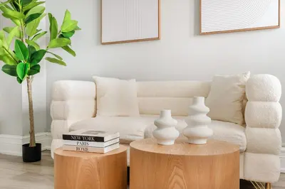 a living room with a couch and two tables with vases at 73-1004 New Studio UWS Doorman Gym in New York