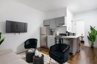 a living room with two chairs and a kitchen at 91-2A Stylish 3BR 2Bth with W D in New York