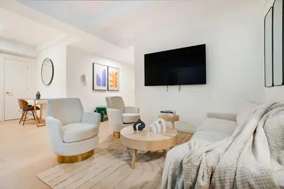a living room with a couch and chairs and a tv at 52-3DE Newly renovated 2BR BTH Midtown East in New York