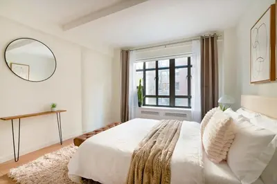 a white bedroom with a large bed and a window at 52-3DE Newly renovated 2BR BTH Midtown East in New York