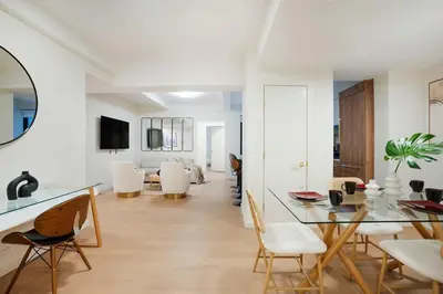a dining room with a glass table and white chairs at 52-3DE Newly renovated 2BR BTH Midtown East in New York